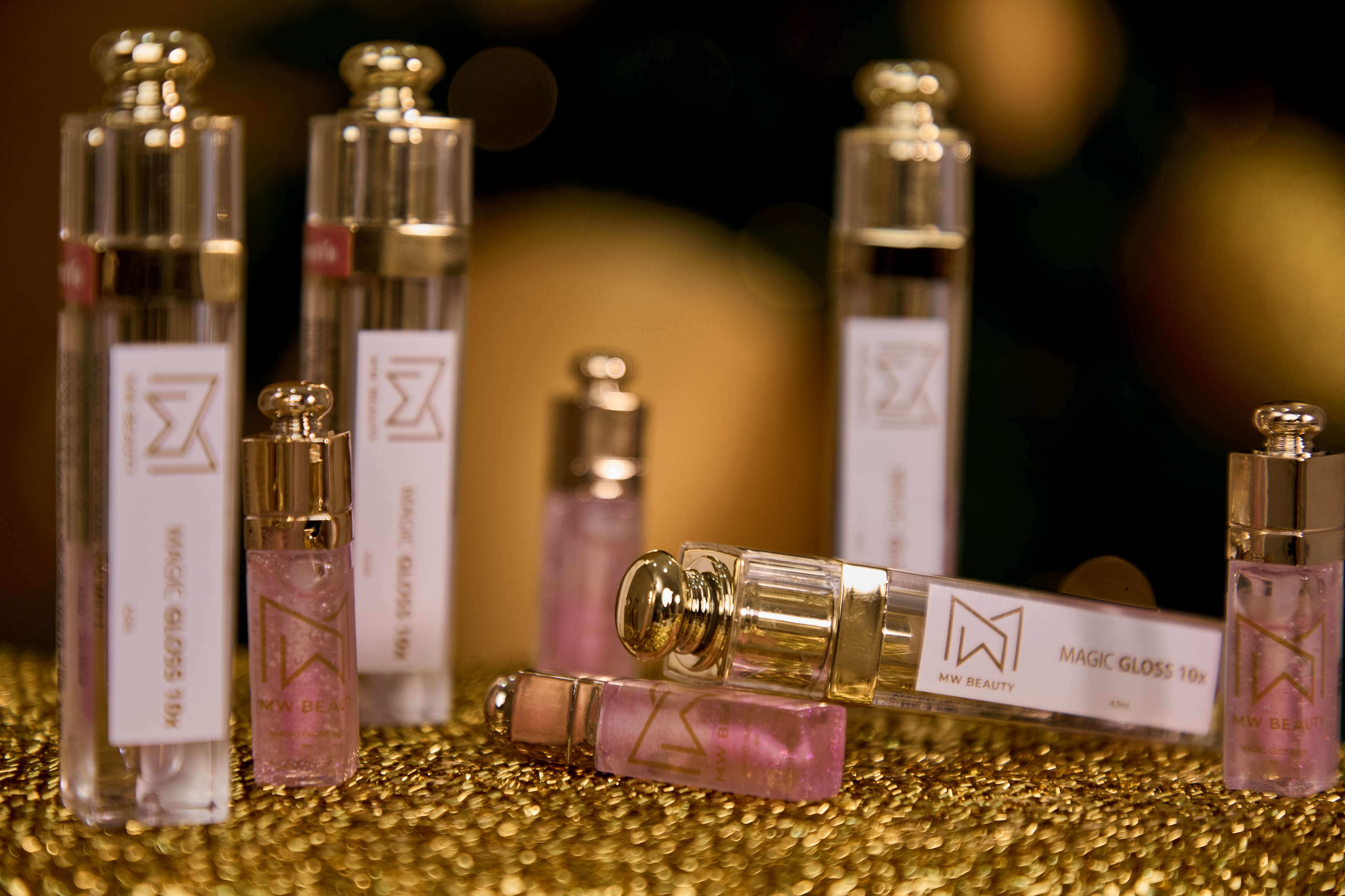 Frascos da linha de cosméticos MW Beauty em cenário dourado